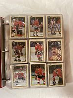 Photo of nine Bowman hockey player cards in protective sleeves displaying front imagery of players in Chicago Blackhawks uniforms