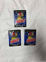 Three sealed 1990 Bowman Premier Edition hockey wax packs in blue foil packaging with red and yellow graphics.