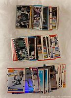 Top view of three piles of Wayne Gretzky hockey cards arranged on a white surface showing card front designs and players in team uniforms.