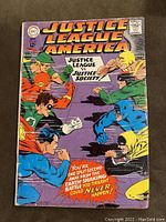 Front cover of Justice League Of America #56 comic, showing members of Justice League and Justice Society in confrontation, with price 12¢ and DC Comics logo.