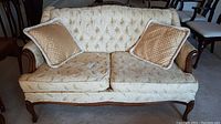 Front view of the Braemore upholstered loveseat with two gold pillows, showing overall sofa condition and cushions.