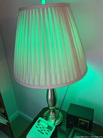 Full image of a brass base table lamp with pleated off-white shade showing size and condition.
