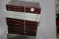 Stack of 13 sealed Great Courses books on Ancient History topics bound with a rubber band showing all spines.