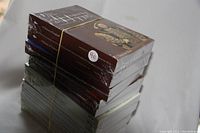 Photo showing stack of 14 Great Courses history books in original shrink-wrapped condition with visible titles and sealed plastic wrap.