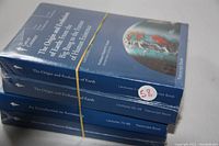 Four sealed blue hardcover transcript books stacked with titles visible, secured with a rubber band.
