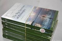 Six sealed hardcover transcript books from The Great Courses series stacked and held with a rubber band, showing the titles and partial cover art.