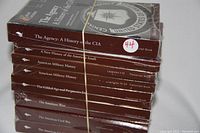 Photo of 8 sealed Great Courses books stacked and bound with rubber band, showing spines with titles related to American history topics.
