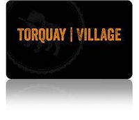 Photo of gift certificate card with 'Torquay | Village' text in orange on black background.