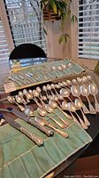 Full layout of folded velvet rolls and silver trays showing knives, forks and spoons