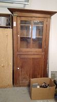 Full front view of the cabinet showing glass upper door, solid lower door and overall wear
