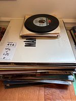 Stack of 45 RPM singles and LP records showing collection size and condition.