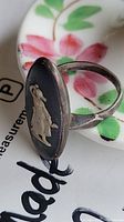 Close-up angled view of the ring showing the oval jasperware cameo with the classical figure in white relief on a sterling silver band.