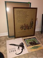Lot overview showing two Tolkien 1988 calendars and a glass frame with backing behind the framed print