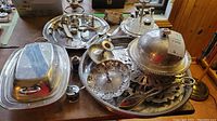 Overview of all silver plated serveware and accessories displayed on table