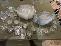Overview of all glass fish-shaped plates, sauce cups, and crab-shaped dishes on table