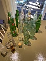Top view of vintage soda and medicine bottles arranged on table showing variety of brands and bottle types.