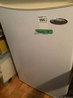 Front view of the Whirlpool bar fridge with the label and dimensions noted on the door.