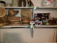 Shelf with multiple woven wicker baskets in various shapes and sizes, and vintage toys including dolls, stuffed animals, and toys cars.