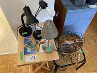 Solid wood TV tray with items on top including three different lamps, two baskets, and some kitchen accessories. Items arranged on and around the TV tray for clear identification.