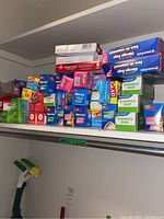 Shelf with multiple boxes of sandwich bags, storage bags, foil, wax paper, and plastic cups