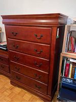 Front and side view showing five drawer highboy dresser with brown wood finish and metal handles.