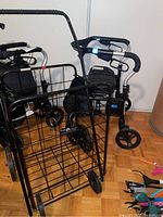 Four-wheeled metal wire foldable shopping cart with larger rear wheels and smaller front wheels