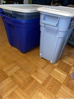 Photo of two large storage totes, one dark blue and one light blue Rubbermaid Roughneck Jr. container, both with white lids.
