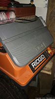 Close-up photo showing the top and side of the Ridgid stationary belt sander including part of the sanding belt.