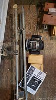Top-down view of Black & Decker router, router slide rails, manuals, and wooden boxes on wooden floor.