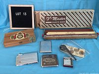 Overview of all items including V-Master cigarette maker box, wooden cigar box, cigarette cases, lighter, and pipe.