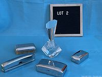 Set arranged on blue background showing all items, including metal holders, hair brush, and glass perfume bottle.