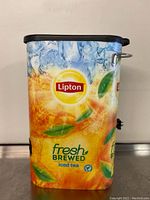 Front angled view showing Lipton iced tea graphic, black smoke lid, and handle on side
