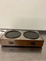 Front view showing two circular electric burners and on/off switches for each burner on the wood panel exterior hot plate.