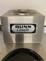 Close-up side view showing Bunn Omatic logo on stainless steel body of coffee pot warmer