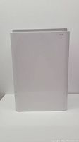 Front view of white Cintas wall-mountable commercial trash can on a white surface with plain background.