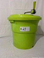 Front view of bright green five gallon salad spinner with crank on lid and side handles