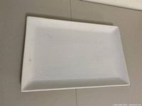 Top-down view of large rectangular white porcelain serving platter showing surface and edges.
