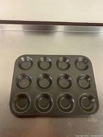 Top view of shallow 12 cavity muffin top pan showing round cavities with non-stick coating.