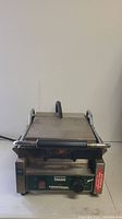 Front view of Waring Panini Perfetto commercial panini grill showing stainless steel body with handle and flat grill surface.
