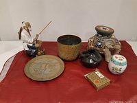 Photo showing full lot of seven Asian vintage decorative items including figurine, bowl, cloisonné elephant, jars, plate, and box