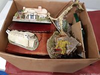 Box containing several miniature decorative houses with varied designs and colors