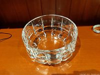 Crystal bowl on wooden surface, showing side and top facets and weight.