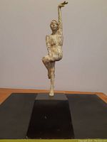 Front view of the metal figure sculpture showing full body posture and black base.