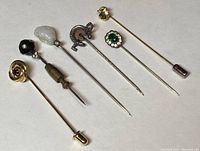 Group of 6 vintage stick pins with varied designs and materials, aligned in a row.