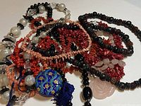 View of assorted costume necklaces showing variety of bead types, colors and pendant styles.
