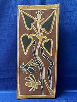 Front view of the Aboriginal spirit bark wall art, showing painted snakes, insects, and plants in traditional style on natural bark.