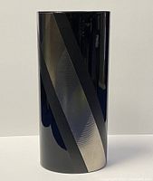 Front view of the black porcelain vase showing metallic and matte diagonal stripes.