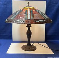 Front view of vintage Tiffany style stained glass leaded table lamp on a white background showing full lamp and base.