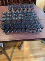 Full group photo showing all approx. 60 pieces of blue-tinted stemware arranged by type on table