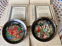 Two painted collectible plates in original boxes with certificates of authenticity, colorful Russian folk legend scenes